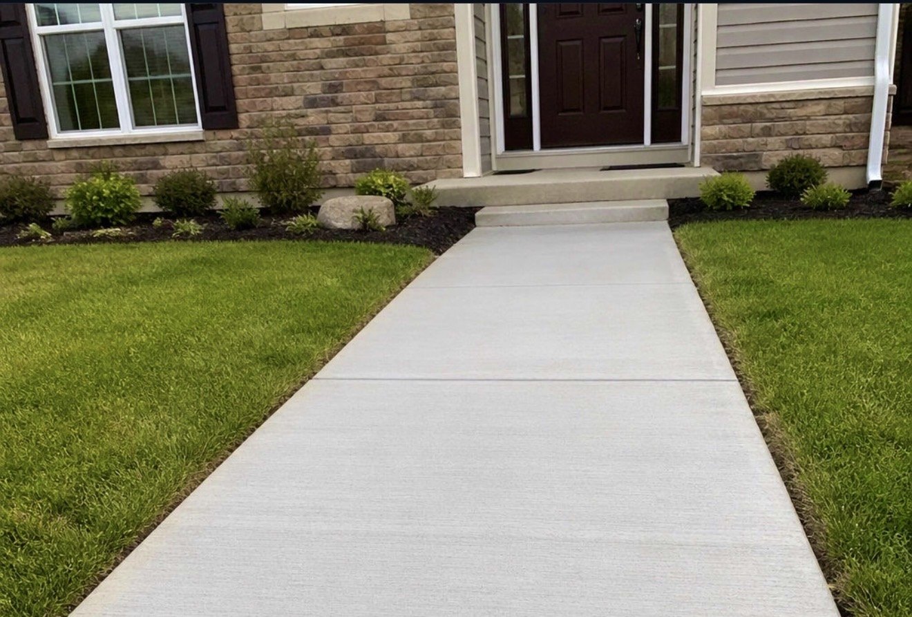Clean concrete front walkway leading to a home's entry